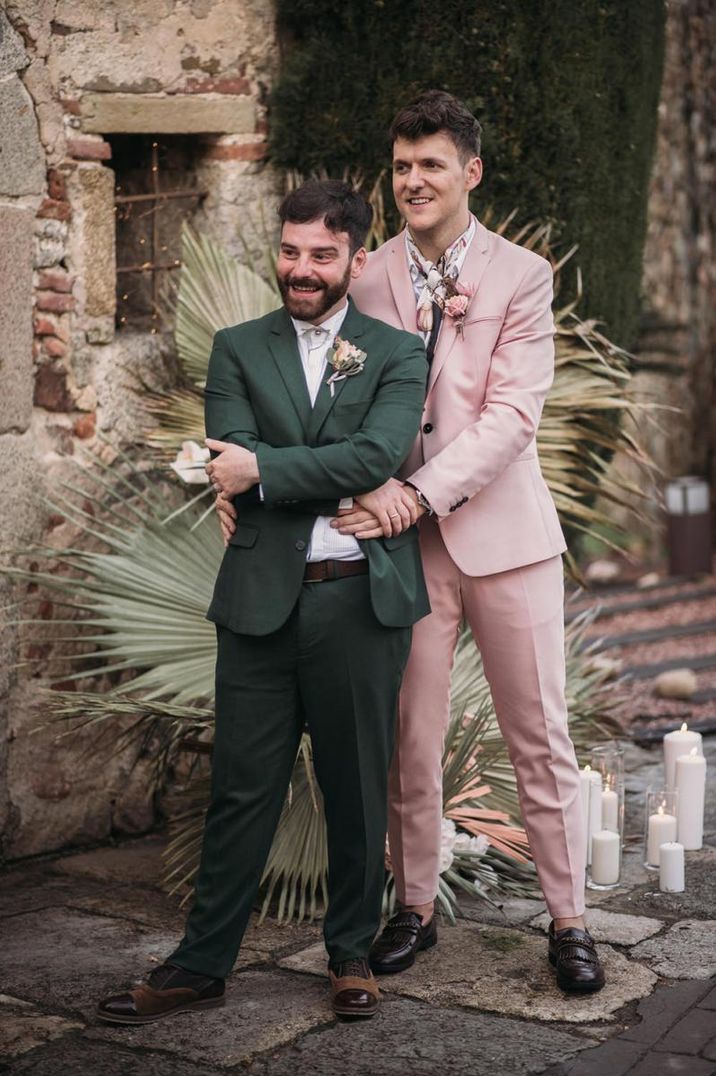 Emotional gay wedding ceremony with grooms in pink and green suits