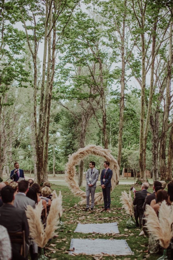 Same sex woodland wedding ceremony with pampas grass moon gate