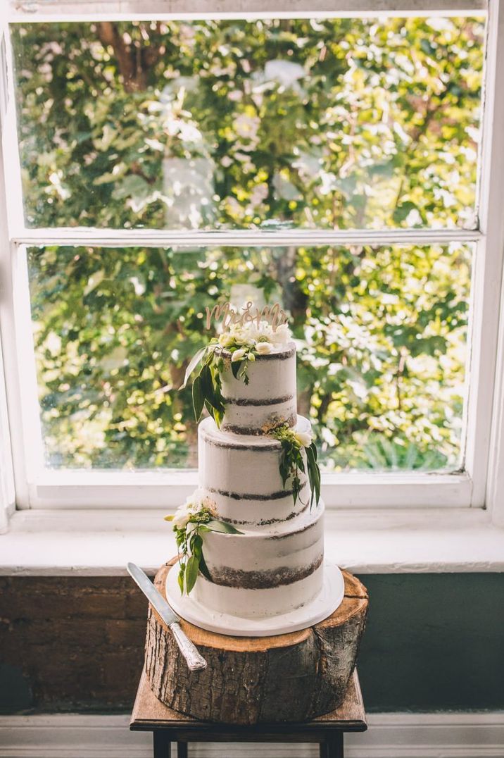 Semi naked wedding cake with greenery decor