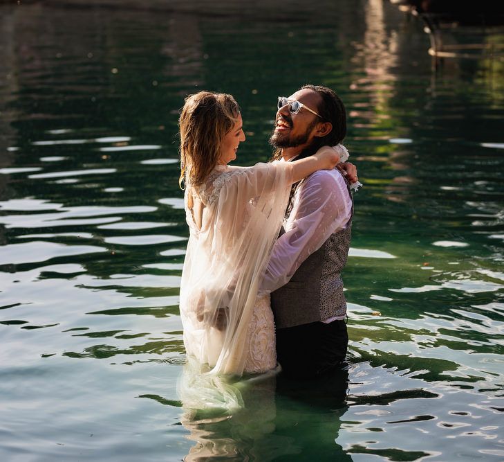 Bride and groom laughing in the lake at Euridge Manor