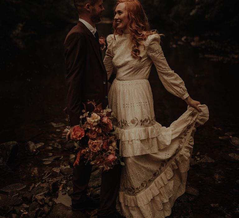 Bride in broderie anglaise wedding dress with tiered skirt 