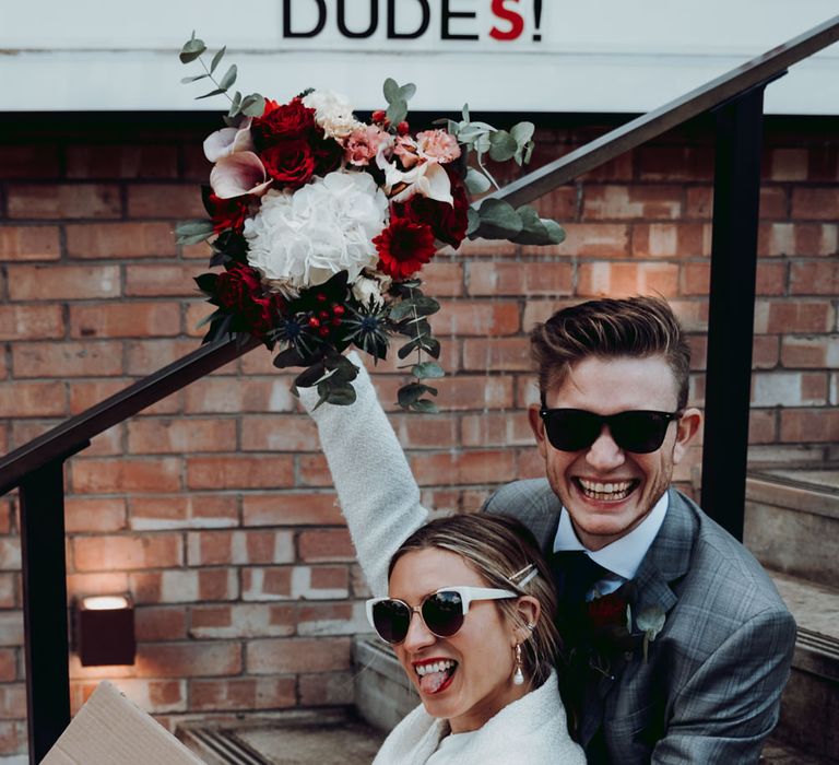 Stylish bride and groom at Manchester micro wedding with cardboard box wedding sign 