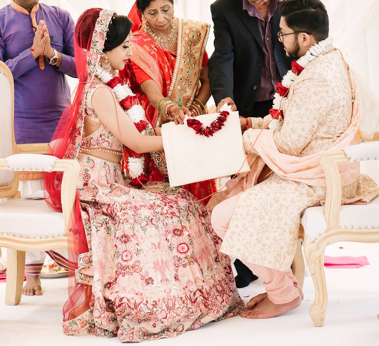 Mother and father of the bride and groom helping with the Hindu wedding ceremony 