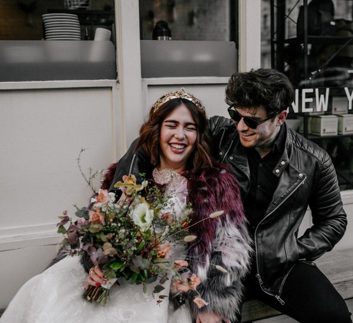 Bride with floral blooms and groom in leather jacket 