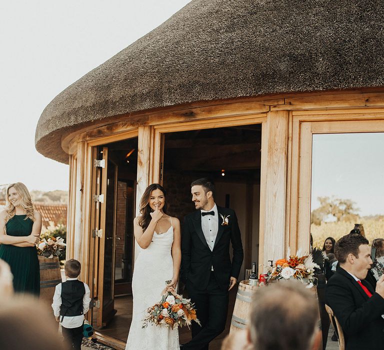 Bride and groom laugh at wedding speeches