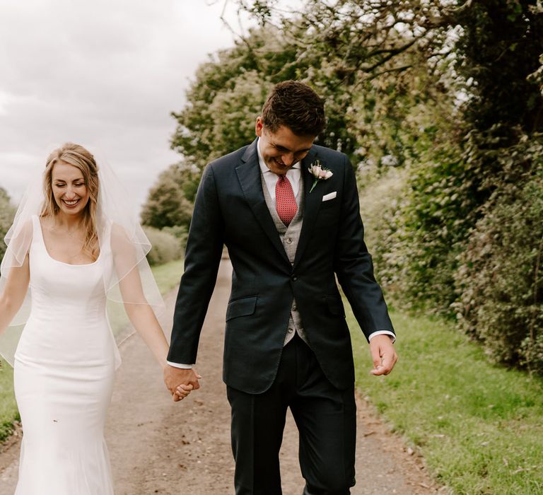 Bride in Suzanne Neville wedding dress and groom in classic suit for country wedding 