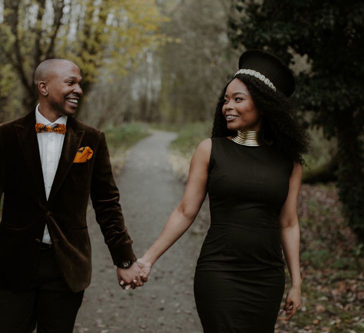 Black African bride and groom holding hands in a country lane 