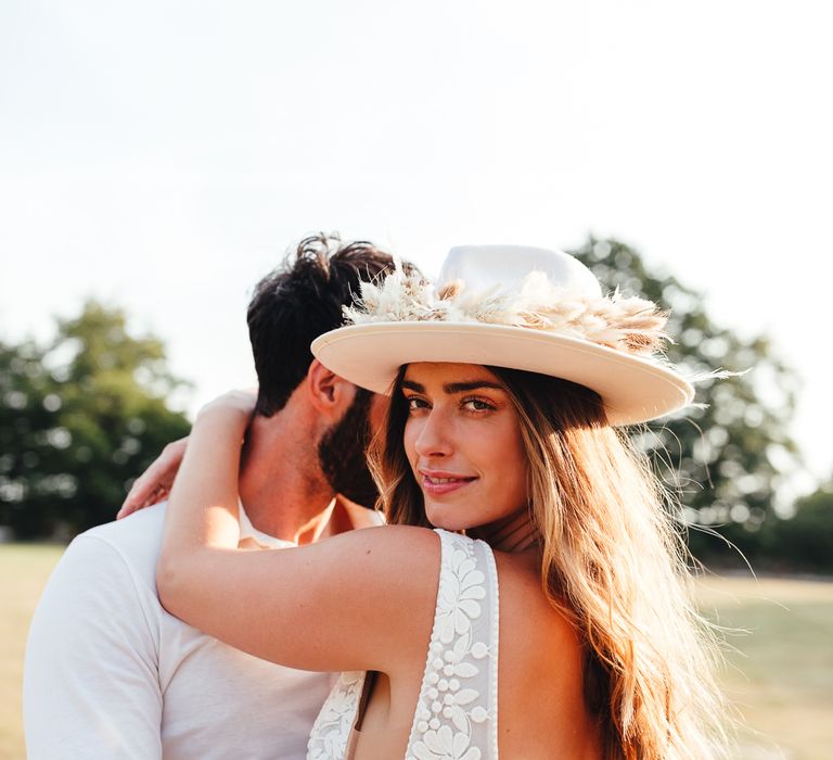 Bride looks back wearing bridal hat