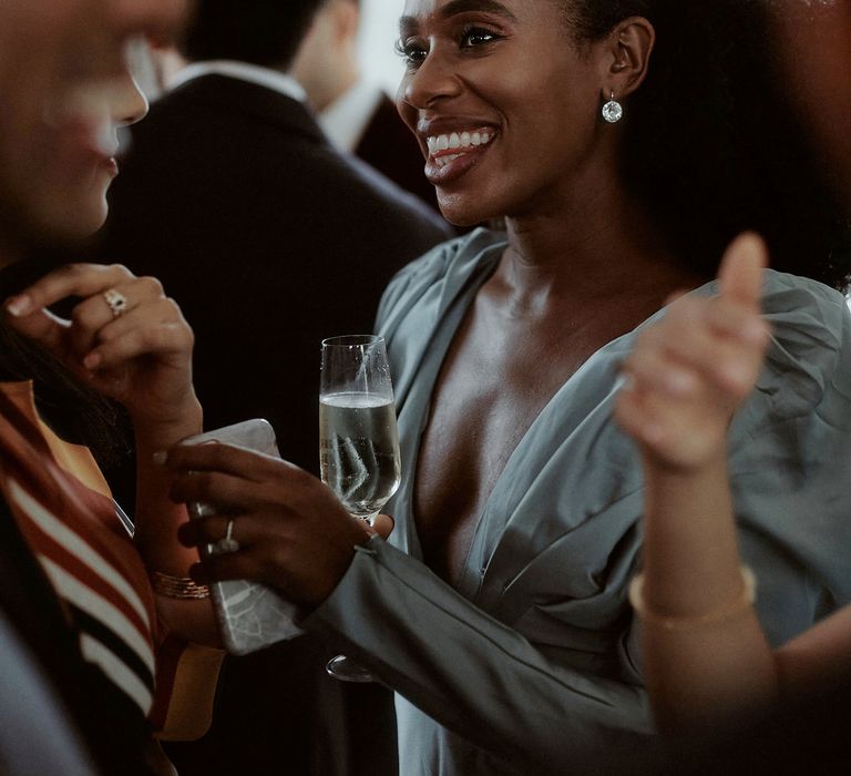 Stylish wedding guest in a grey satin dress at an industrial wedding 