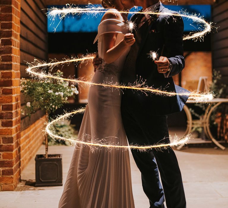 Bride & groom hold sparklers and a ring of light surrounds them from top to bottom