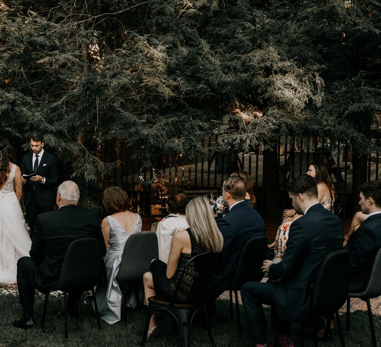 Bride & groom outdoors surrounded by wedding guests