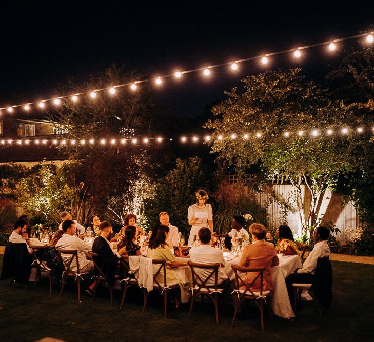 Intimate garden wedding reception with festoon light decor 