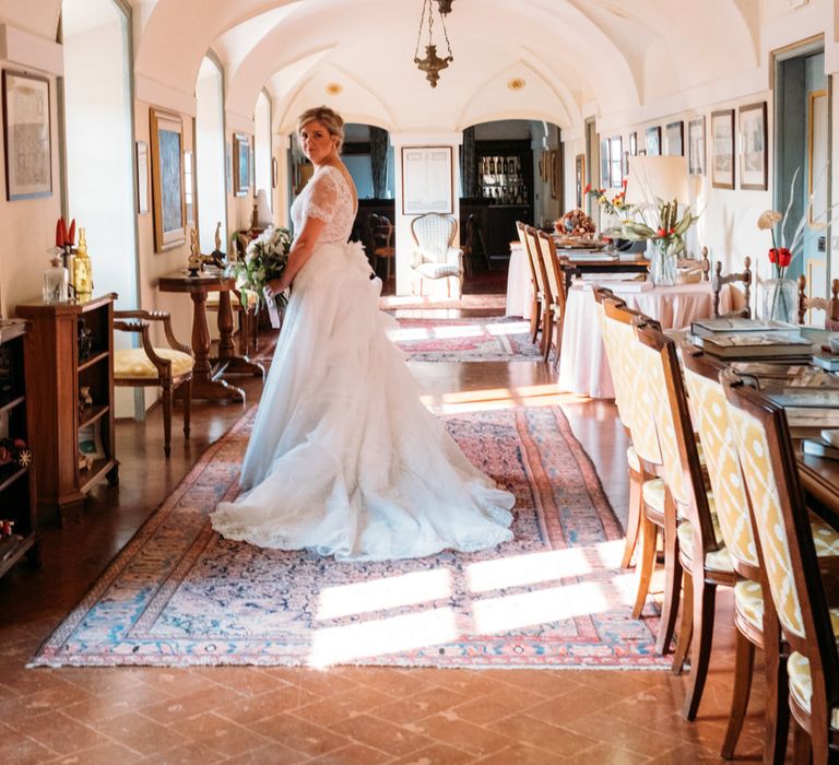 The bride getting ready in her Sofia Haute Couture gown with ruffled skirt and lace short sleeves