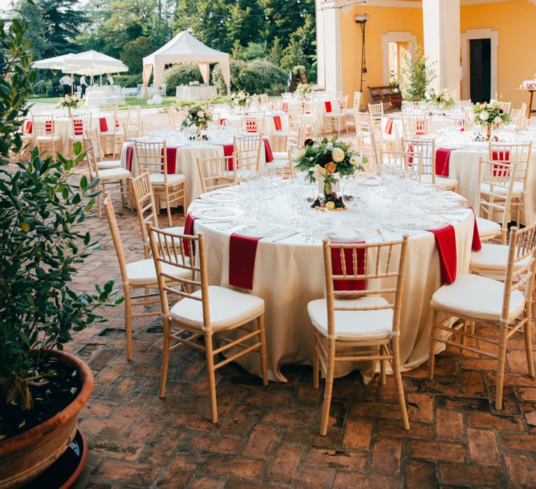 Round tables, red and white decor and bistro lights in the courtyard