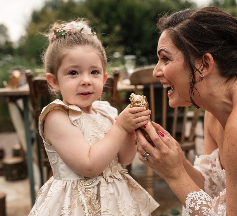 Bride and little girl look at golden ornament 