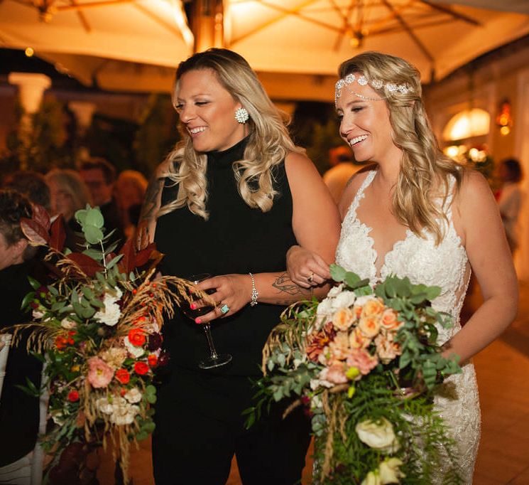 The brides walking arm in arm through their evening wedding reception