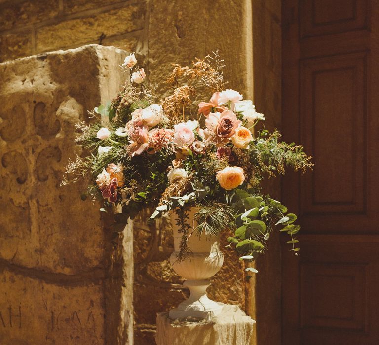 Blush pink urn floral arrangements with foliage 