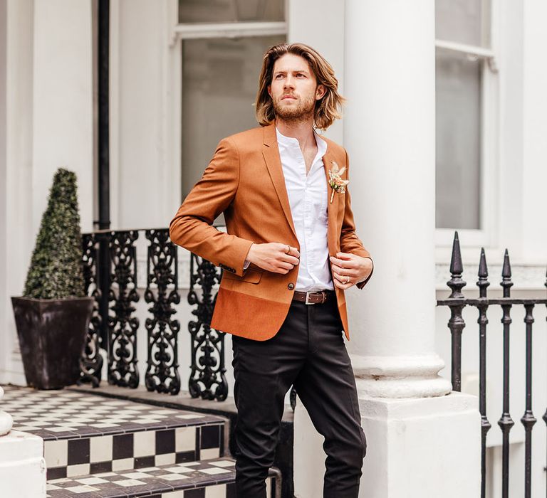 Stylish groom black trousers, brown shoes, white shirt and rust blazer for intimate town hall wedding 