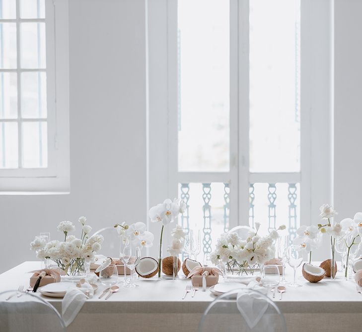 Intimate minimalist wedding table decor with orchid wedding flowers, coconuts and wooden beads