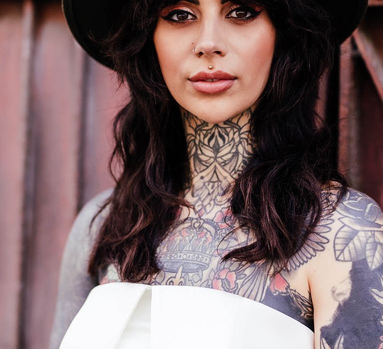 Bride with a fringe wearing a fedora hat showing her smokey eye shadow and eyeliner bridal makeup 