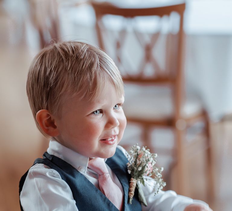 Little boy wears blue waistcoat and pink tie