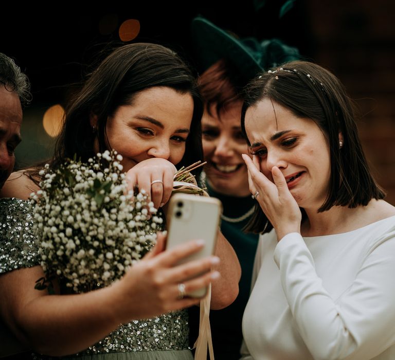 Emotional bride FaceTiming wedding guests that could be at her intimate wedding 