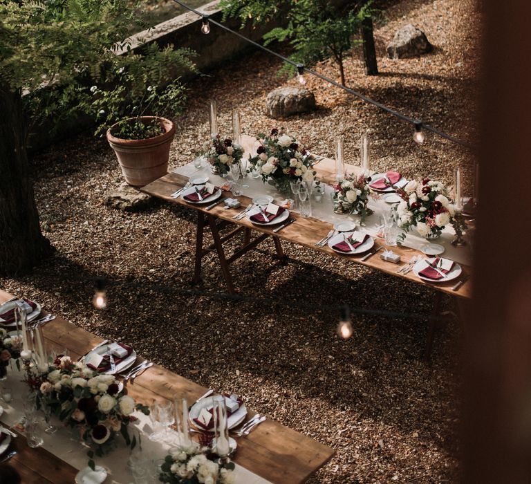 Rustic outdoor wedding reception surrounded by trees in Italian countryside 