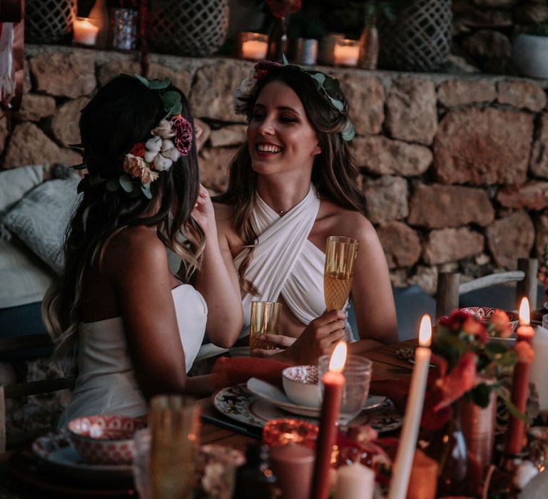 Two brides celebrating with champagne at Ibiza beach elopement