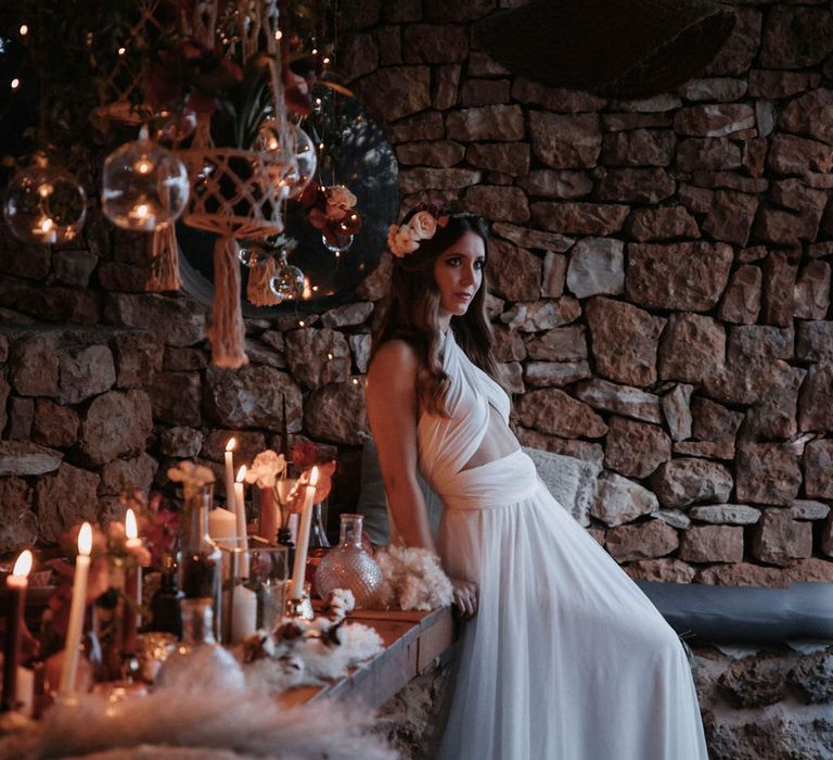 Bride wearing adjustable strap tulle wedding gown with cut out detail by a candlelit tablescape