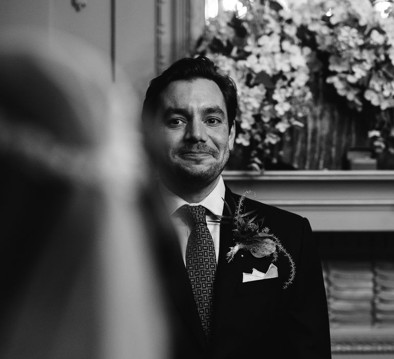 Groom in a Hawes & Curtis suit waiting at the altar for his bride 