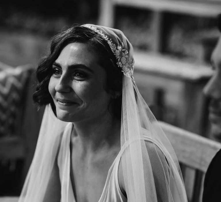 Black and white portrait of an emotional with wavy bobbed hair in a Juliet cap wedding veil 