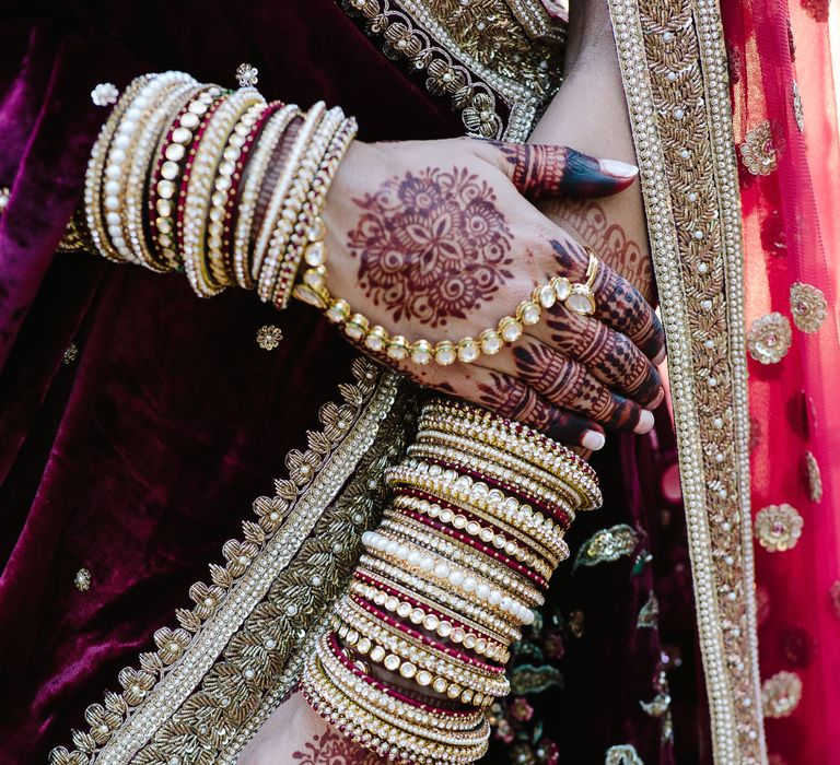 Bride wears bangles up her arm and traditional mehndi 