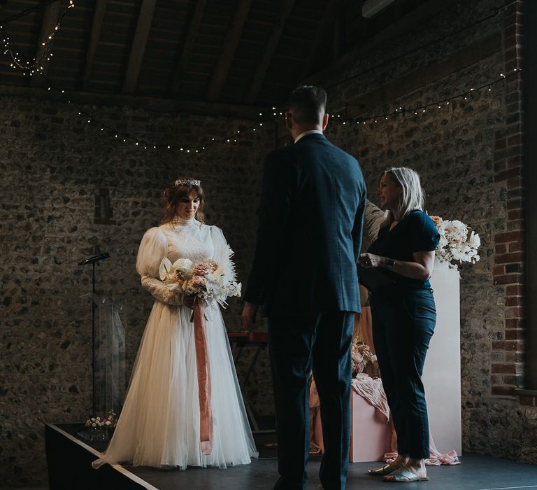 Bride & groom during wedding ceremony as bride wears gothic fairytale style wedding gown