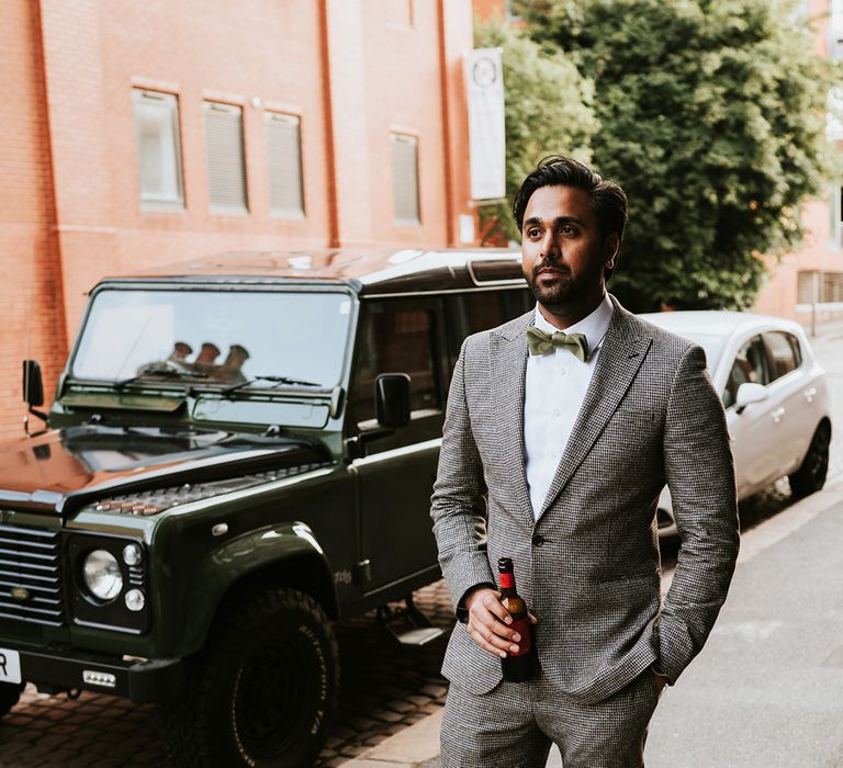 An Indian groom wears a grey suit and bow tie for a wedding in Sheffield.