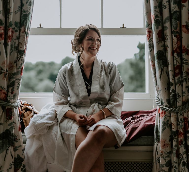 Bride on the wedding morning in a silk getting ready robe 