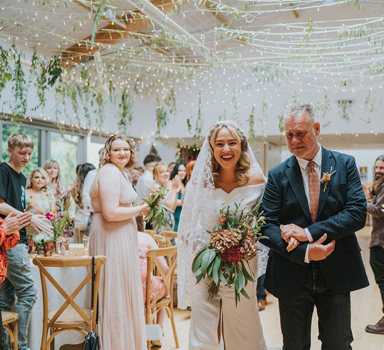 Bride walks down the aisle with her father on her wedding day