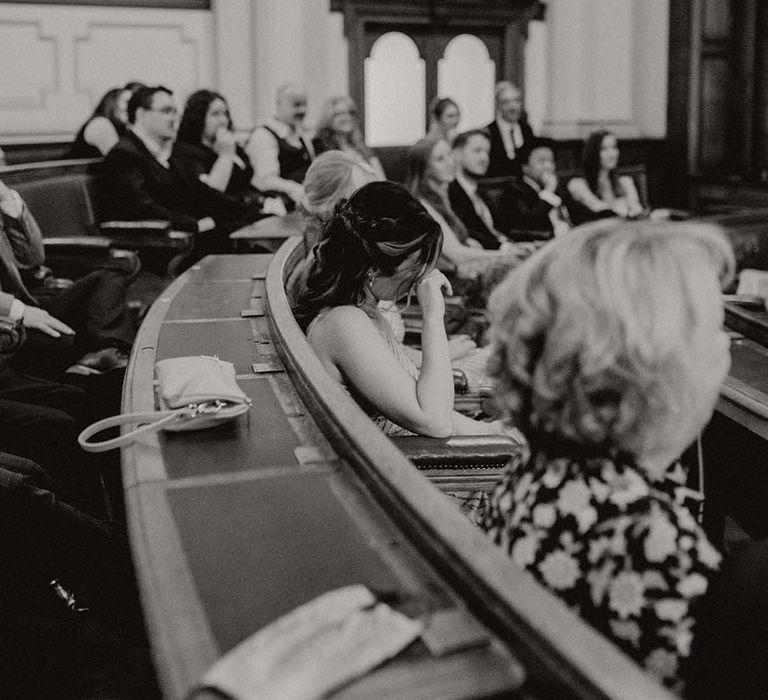 Guest becomes emotional and wipes her eyes during wedding ceremony