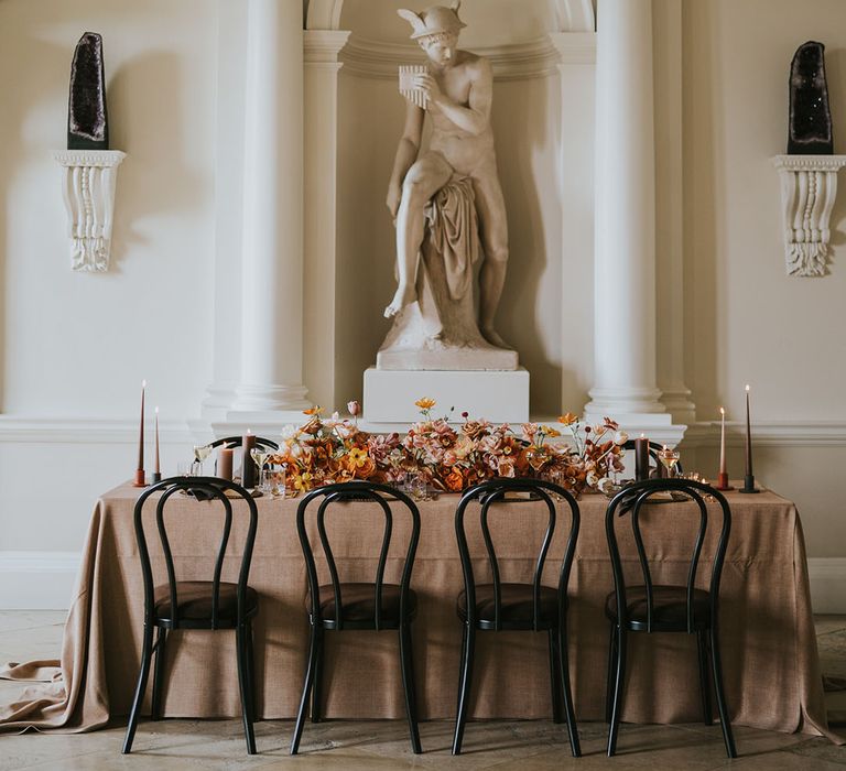 Modern reception at Kirtlington Park wedding venue in Oxfordshire with black chairs, natural linens and orange flowers 