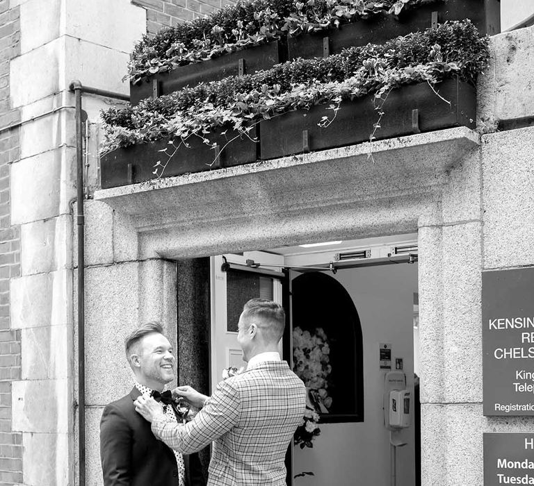 Grooms laugh outside Chelsea Old Town Hall