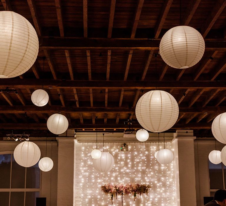 White hanging paper lanterns at Trinity Buoy Wharf for wedding with fairy lights and flower cloud