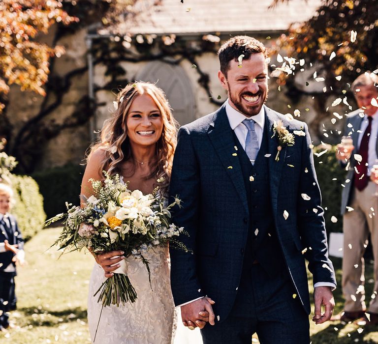 Bride and groom smile brightly as they have their confetti exit 