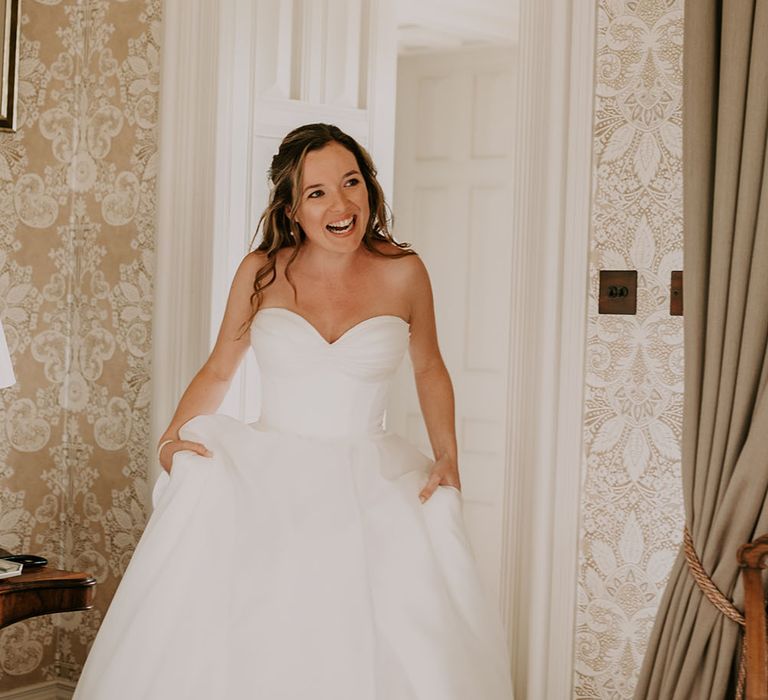 Bride wears Suzanne Neville wedding dress with full princess skirt and sweetheart neckline