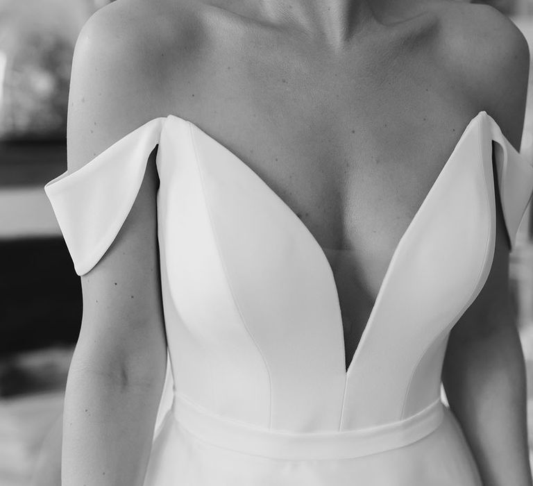 Bride wears strapless Suzanne Neville wedding dress with off-the-shoulder detailing and fitted style with plunge neckline 