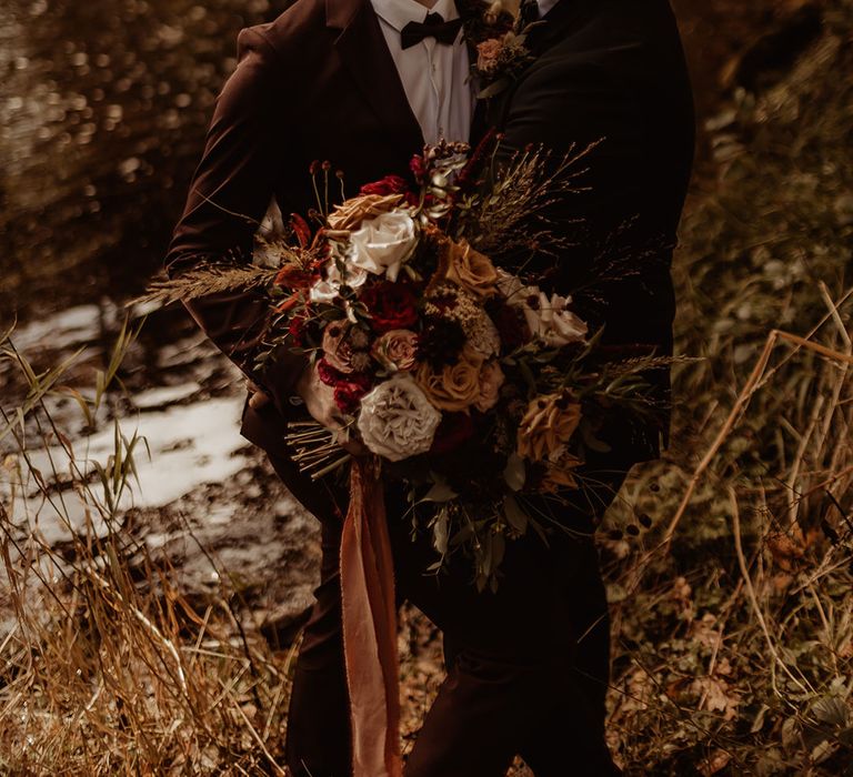 Grooms laugh together looking out at the stunning nature surrounding Hidden River Cabins 