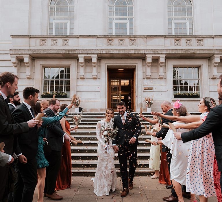 Bride & groom leave Hackney Town Hall as wedding guests throw colourful confetti