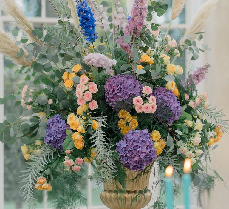 Colourful floral arrangement in gold vase 