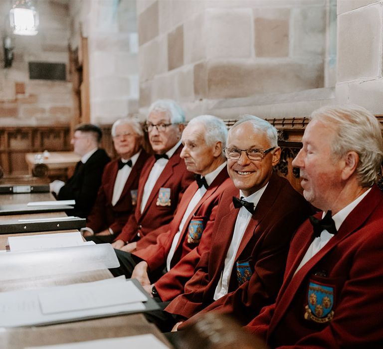 The choir all wearing matching maroon blazers with logo 