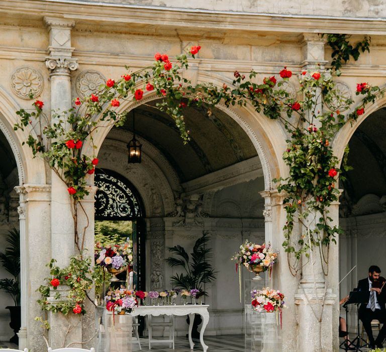 Bright and colourful wedding flower decorations with pink, red, purple, and orange wedding flower aisle decorations 