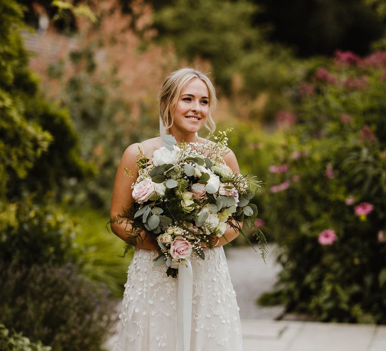 Pink and white rose classic wedding bouquet held by the bride in an Alexandra Greco wedding dress