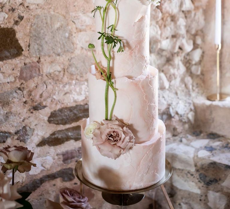 Four tier buttercream wedding cake with decorative blush garden rose and rose stalk at Pentney Abbey wedding